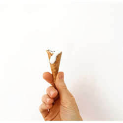 Cropped hand of person holding food against white background