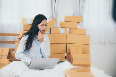 Young woman using mobile phone in box