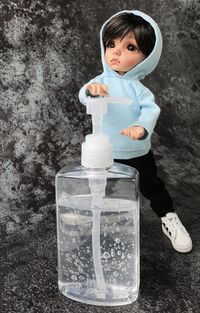 Portrait of boy holding ice cream standing against bottle