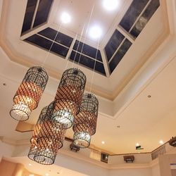 Low angle view of illuminated pendant lights hanging from ceiling