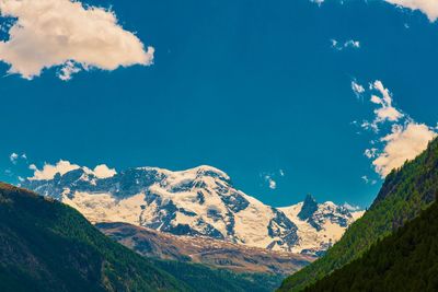 Scenic view of mountains against blue sky