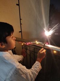 Rear view of boy looking at illuminated christmas lights