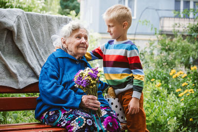 Grandparents day, reunited family, togetherness. senior old grandma hugs grandson outdoors