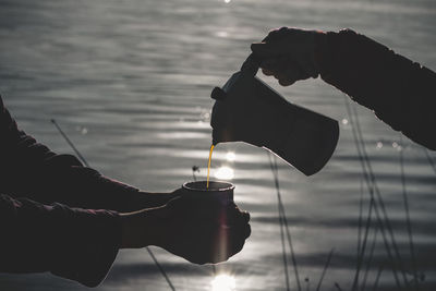 Cropped image of hand holding ice cream against the sky