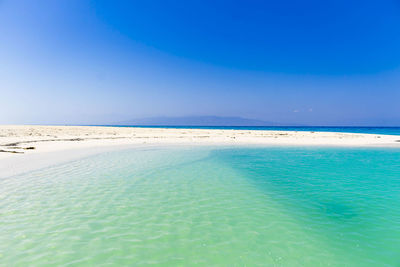 Scenic view of beach against blue sky