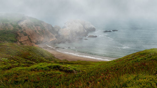 Scenic view of sea and mountains against sky