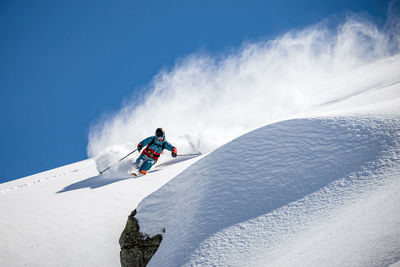 Low angle view of man skiing on snow covered mountain