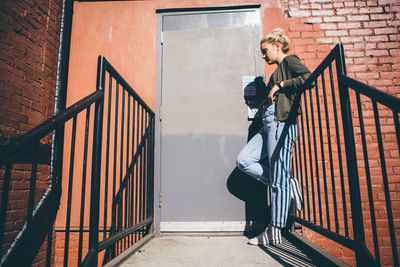 Full length of woman standing on staircase