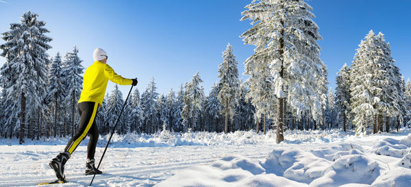 Mature woman skiing on snow covered forest