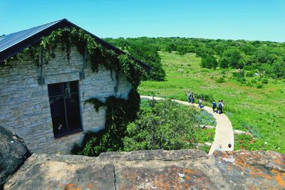 Built structure by trees and building against clear sky