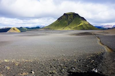 Scenic view of land and mountains against sky