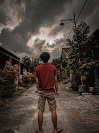 Rear view of man on street against sky