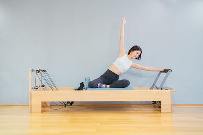 Side view of woman exercising on floor