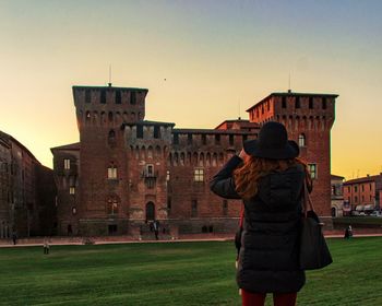 Rear view of man and woman standing against building