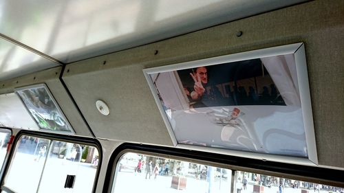 Low angle view of people seen through glass window