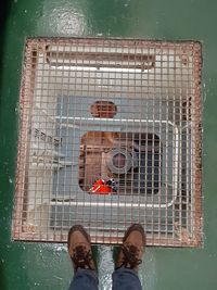 Low section of man standing by metal structure