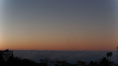 Silhouette buildings against sky during sunset