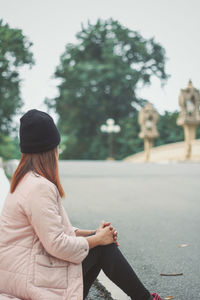 Rear view of woman sitting outdoors