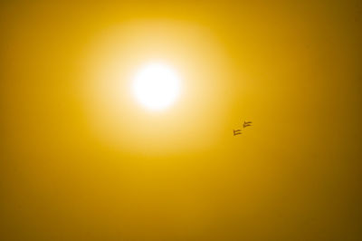 Low angle view of airplane against sky during sunset