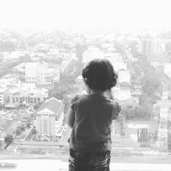 Rear view of man in city against sky