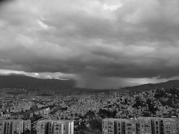 Aerial view of city against cloudy sky