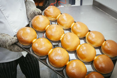 Midsection of chef baking breads in kitchen