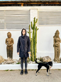 Portrait of woman standing against wall
