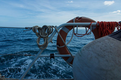 Life belt on boat in sea against sky