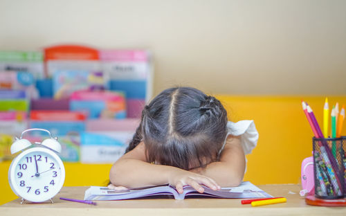 Close-up of girl sitting by table