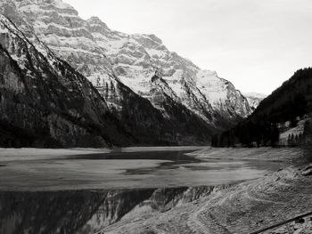 Scenic view of lake by mountains against sky