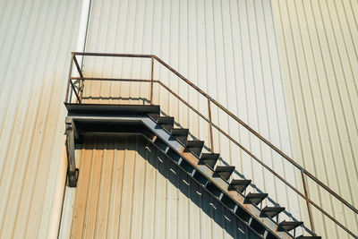 Low angle view of steel staircase against an industrial building