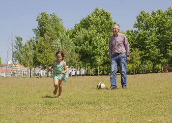 Granddaughter playing with grandfather at park