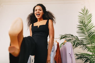 Smiling young woman standing against wall