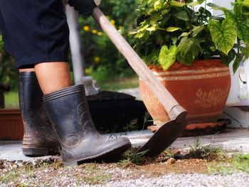 Low section of man with potted plants in yard