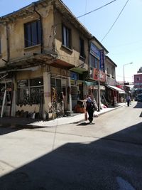 People walking on street against buildings in city