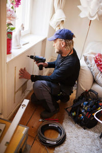 Man drilling in living room