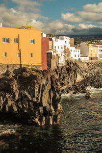 Buildings by sea against sky in city