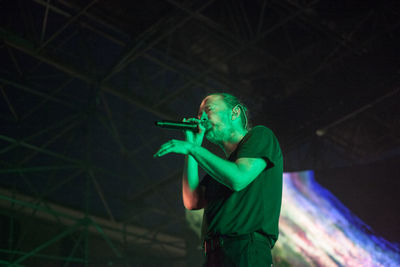 Full length of young man holding illuminated light at night