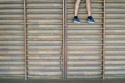 Low section of man exercising on wall bars