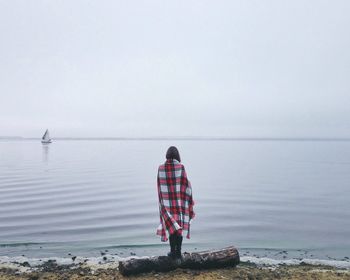 Rear view of woman standing on beach