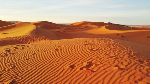 Sand dunes in desert against sky