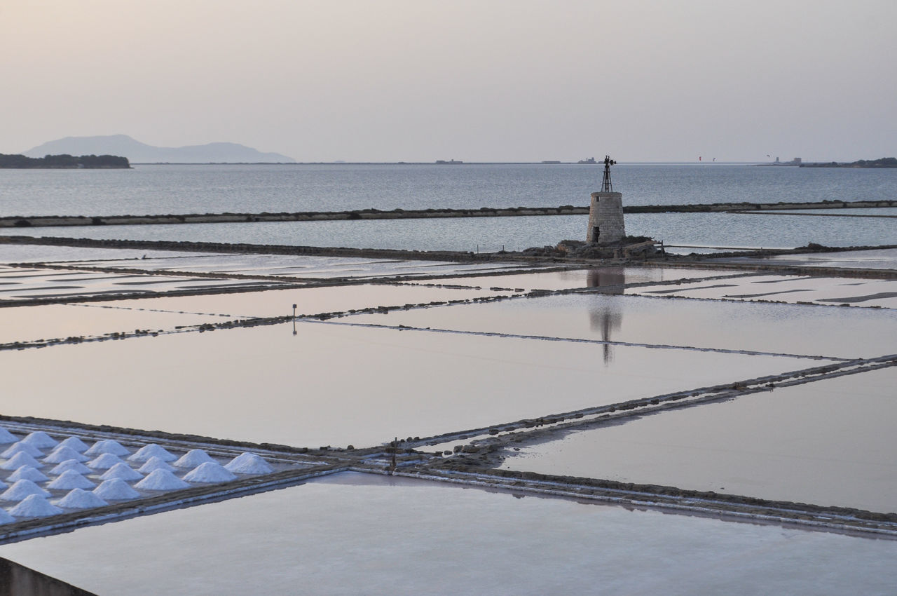 water, salt evaporation pond, environment, sea, sky, salt - mineral, nature, scenics - nature, landscape, land, beauty in nature, architecture, mineral, salt flat, salt basin, tranquility, industry, winter, environmental conservation, no people, business finance and industry, shore, built structure, tranquil scene, outdoors, reflection, lagoon, agriculture, social issues, travel, travel destinations, day, snow, beach, rural scene, business, transportation, building, non-urban scene, occupation, cold temperature, idyllic, pattern, in a row, food and drink, tourism