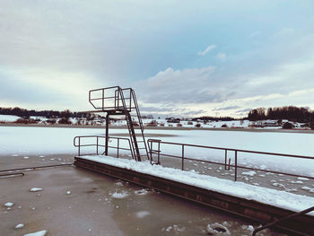 Snow covered railing against sky