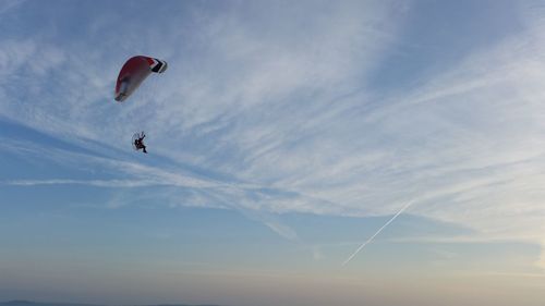 Low angle view of person paragliding against sky