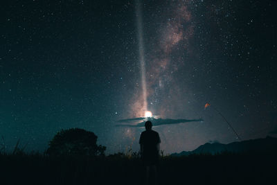 Silhouette man standing against sky at night