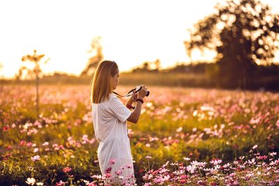 Woman with arms outstretched standing on field