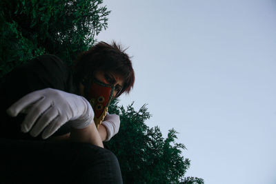 Rear view of girl holding plant against sky