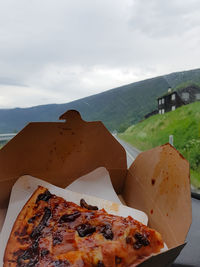 Close-up of pizza on plate against sky