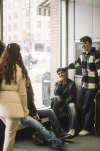 Smiling male and female teenage friends spending leisure time at mall