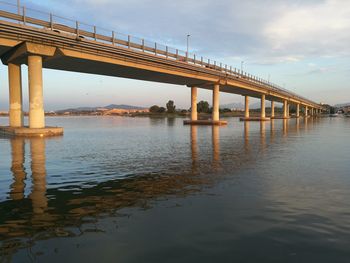 Pier on bridge against sky during sunset